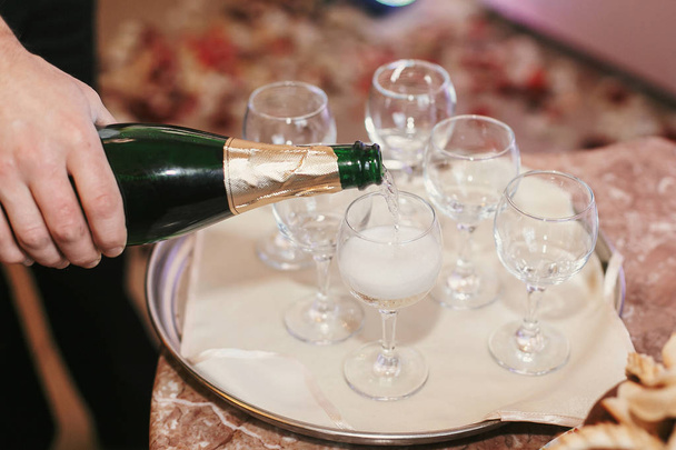 結婚披露宴で空からすにシャンパンを注いでウェイター。休日の祭典。高級レストランのケータリング - 写真・画像