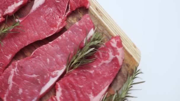 rohe New-York-Streifen-Steaks auf einem Holzschneidebrett. - Filmmaterial, Video