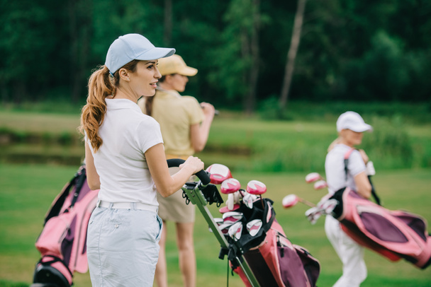 foyer sélectif des femmes en casquettes avec équipement de golf marche sur la pelouse verte au terrain de golf
 - Photo, image