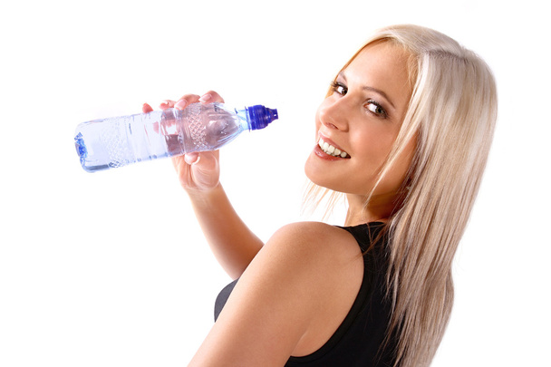 Frau in Fitnesskleidung hält Wasser in der Hand - Foto, Bild