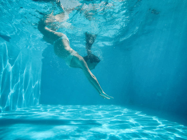 Pregnant woman under the water of a pool - Photo, Image