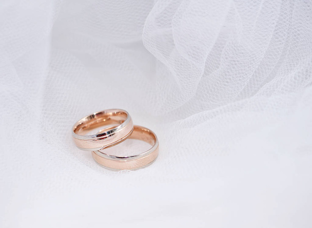 結婚指輪。結婚式のシンボル、属性。休日、お祝い。マクロ。ぼかし。盗難本文コピー スペース パノラマ バナー形式で白いテクスチャ バック グラウンド側での結婚指輪 - 写真・画像