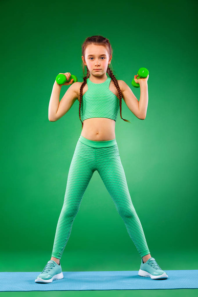 Kid doing fitness exercises at home in her room - Foto, afbeelding