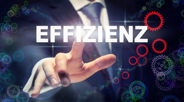 Biznesmen, naciskając efektywności "Effizienz" przycisk w języku niemieckim na futurystyczny monitor - Zdjęcie, obraz