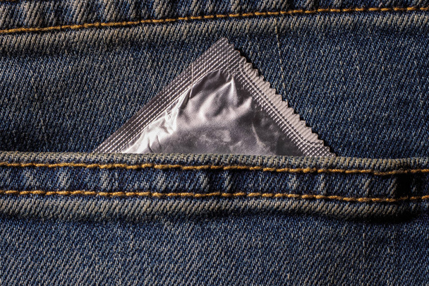 ブルー ジーンズのポケットにコンドームは自分使用にコンドーム、使用の準備ができて保持 condom.a 女性を守る - 写真・画像