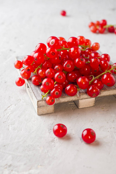 Fresh red currant berries on the stand and grey table. - Valokuva, kuva