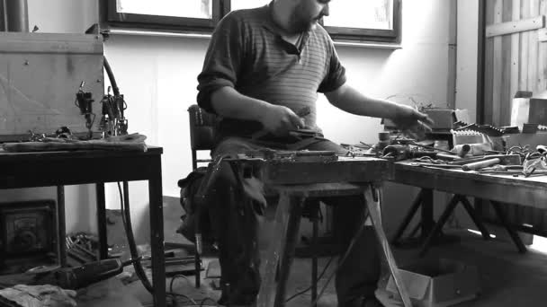 Craftsman is making figure with metal wire in his workshop. Artist is processing metal with special tools in his hands to curve wire in right shape.  - Footage, Video