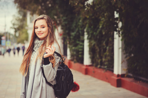 street style portrait of young beautiful happy girl walking in autumn city with trendy leather backpack - Фото, зображення