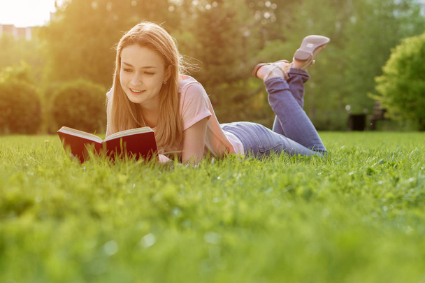 girl on the lawn reading a book - Fotoğraf, Görsel