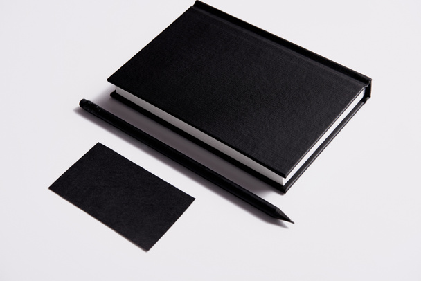 ビジネス カードと鉛筆で黒いノートの等角図でモックアップの白いテーブルの上 - 写真・画像