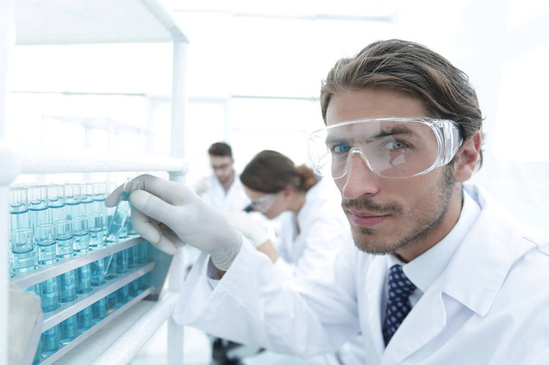 man in goggles to check fluid in vitro. - Foto, Imagen