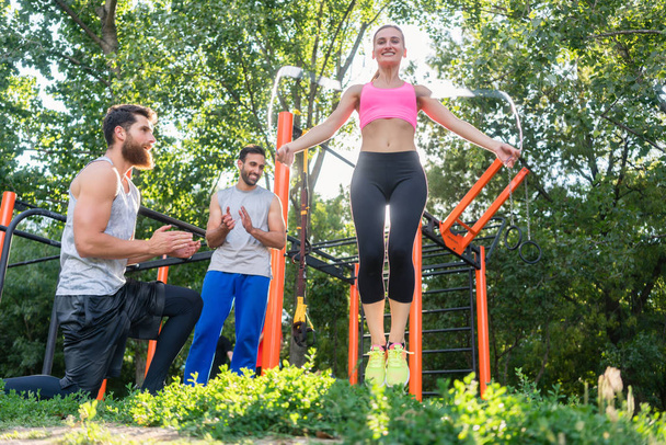 Beautiful woman jumping rope in the applauses of her friends during workout - Fotoğraf, Görsel