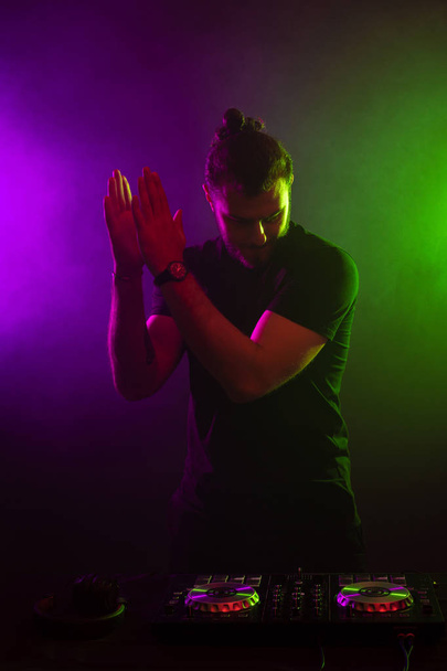 DJ tocando música en el mezclador sobre fondo brumoso colorido
 - Foto, imagen