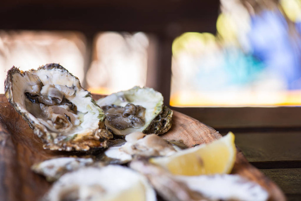 Oysters with lemon on wooden plate. Aphrodisiac for Men power. - Photo, Image