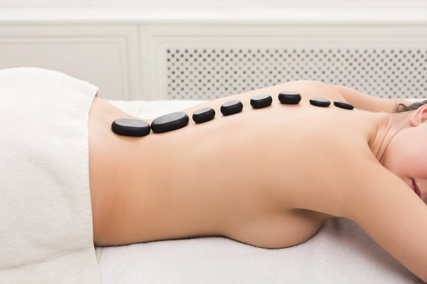 Vrouw getting hot stones massage in de spa salon - Foto, afbeelding