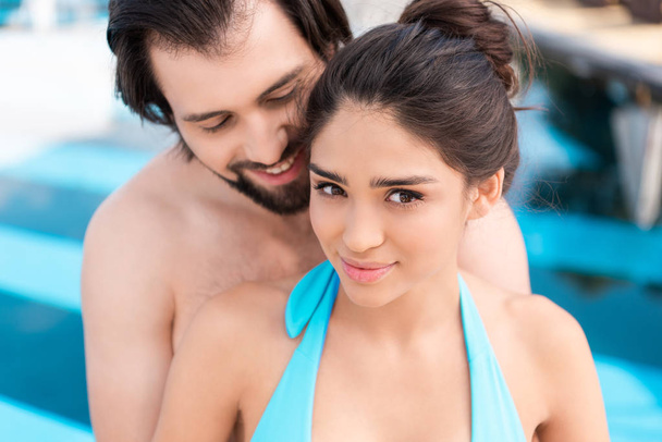beautiful young couple posing near swimming pool - Фото, зображення
