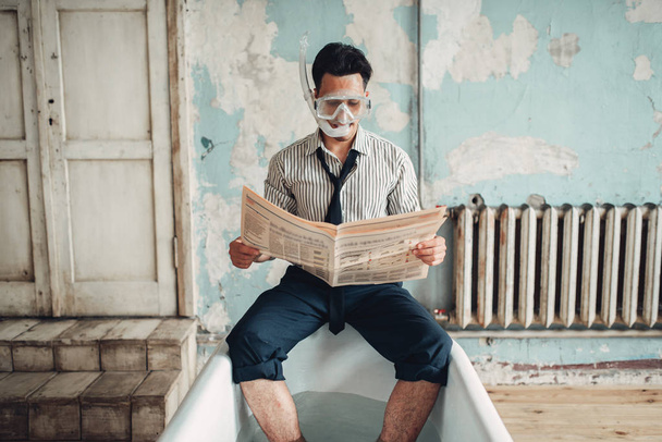Funny businessman in flippers in bathtub reads newspaper, humor. Business lottery or fortune concept - Foto, imagen