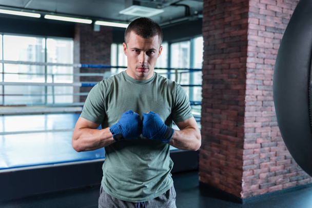 Dark-eyed athlete motivating himself for important boxing competition - Фото, изображение