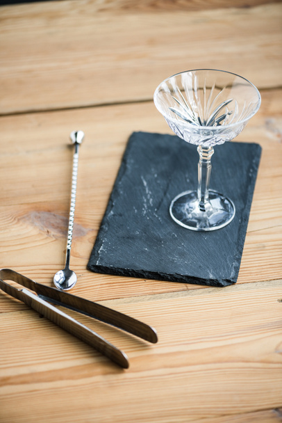 close-up view of margarita glass on slate board and tongs on wooden table - Foto, Imagem
