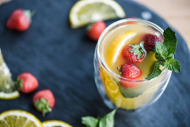 close-up view of refreshing summer cocktail with strawberries and mint on slate board - Fotoğraf, Görsel