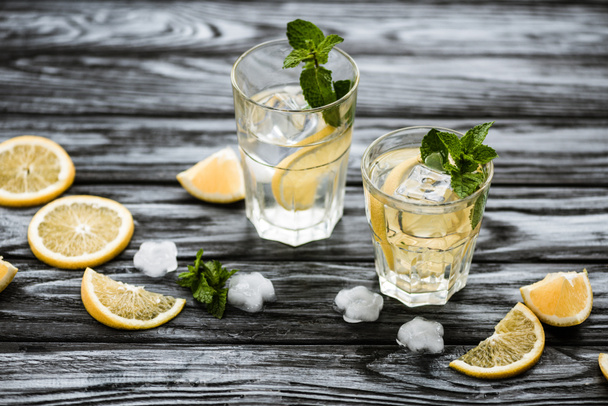 high angle view of glasses with mojito cocktail and ingredients on wooden table - Фото, зображення