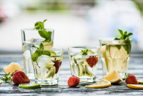 Vista de cerca de vasos con bebidas frescas frías de verano sobre mesa de madera
 - Foto, Imagen