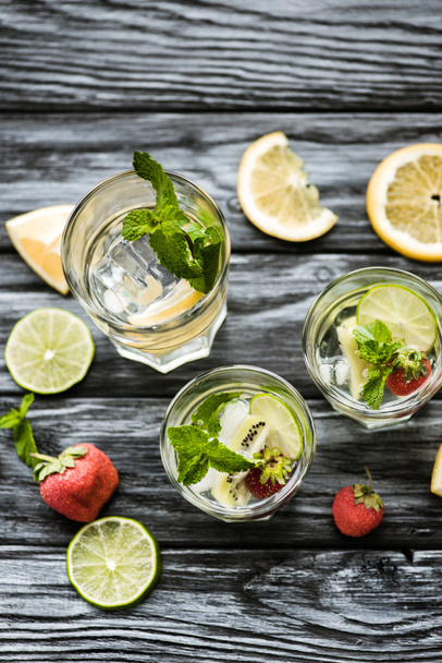 delicious cold summer cocktail with mint, strawberries and kiwi in glasses on wooden table  - Photo, Image
