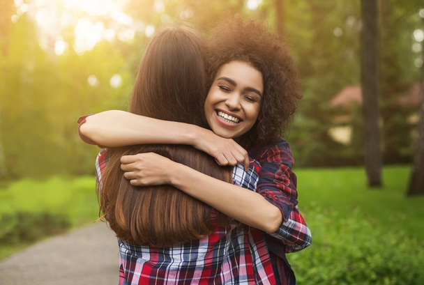 Two happy young girls hug each other outdoors - Photo, Image