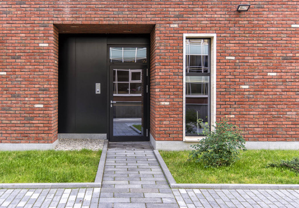 The entrance to the store. Glass door in the house in loft style. Red brick house. The lawn in front of the house. - Foto, afbeelding