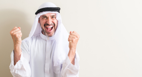 Ανώτερος Αραβικά άνθρωπος ουρλιάζοντας περήφανος και γιορτάζει τη νίκη και την επιτυχία πολύ ενθουσιασμένος, ζητωκραυγάζει συγκίνηση - Φωτογραφία, εικόνα