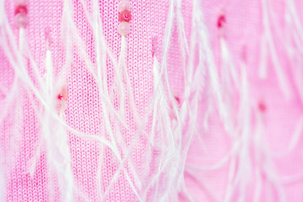 Close-up big soft knitted pink cashmere scarf decorated with sequins and ostrich feathers. Stylish delicate handmande woolen wrap with decor. Tender yarn background texture. - Фото, изображение