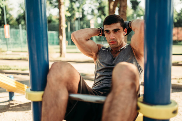体操、屋外フィットネス トレーニング スポーツ ウエアで男。公園内のスポーツ トレーニングの強いスポーツマン - 写真・画像