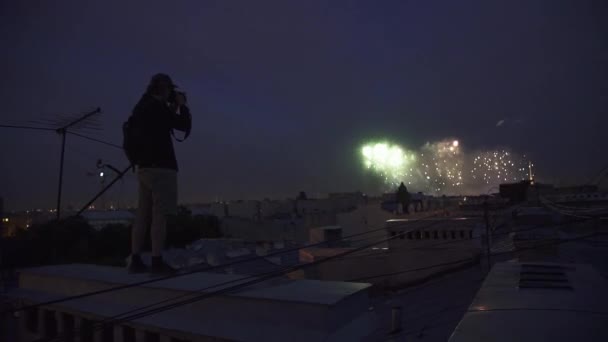 Giovane uomo in piedi sul tetto dell'edificio scattare foto di fuochi d'artificio a macchina fotografica
 - Filmati, video