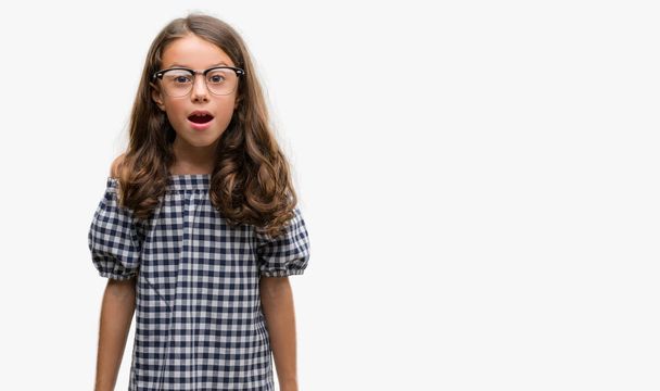 Brunette hispanique fille portant des lunettes peur en état de choc avec un visage surprise, peur et excité par l'expression de la peur
 - Photo, image