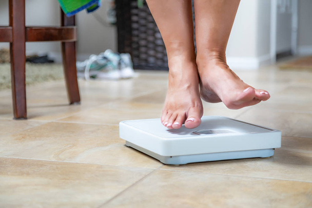 Woman Floating Slightly Above Sruface of Weight Scale. - Photo, Image