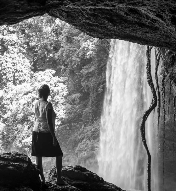 Turista v jeskyni prohlíží Misol Ha v podobě vodopádu poblíž Palenque v Mexiku v černé a bílé - Fotografie, Obrázek