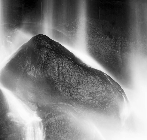 Waterval op rotsen onderin Misol Ha, Palenque, Chiapas, Mexico in zwart-wit - Foto, afbeelding