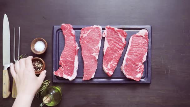 Raw New York strip steaks in cast iron frying pan. - Footage, Video