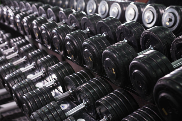 Black dumbbell set in sport fitness center. Weight Training Equipment concept. - Φωτογραφία, εικόνα