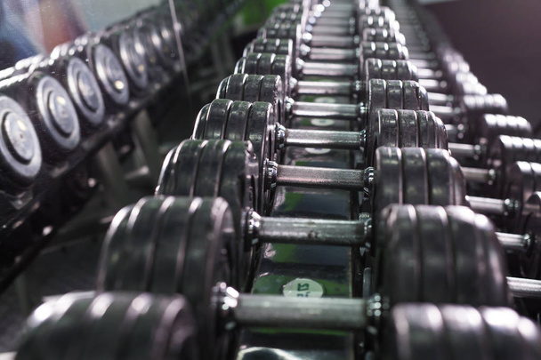 黒のダンベルはスポーツ フィットネス センターで設定します。重量の訓練用器材のコンセプト. - 写真・画像