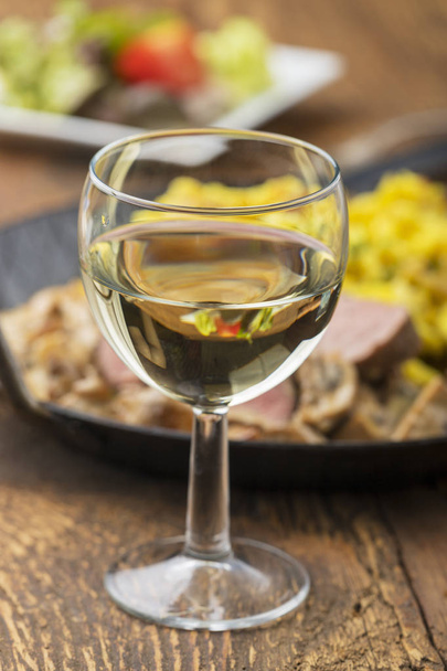 white wine and swabian pork filet with spaetzle on wood  - Фото, изображение