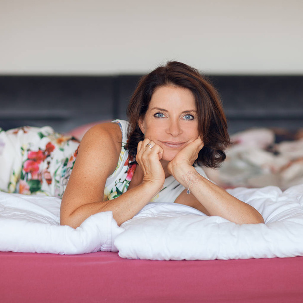 beautiful best age woman lying on bed relaxing, enjoying life, carefree, happy mood - Photo, image