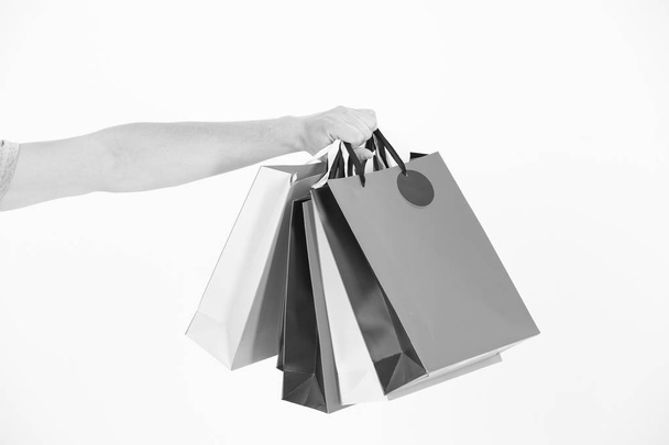 Shopping bags in hand. Paper bags of different colors. Bags or paperbags isolated on white. Shopping during sale and black friday concept. Holidays preparation and celebration. Gift and present - Foto, Imagem