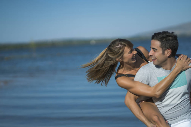 Romantic couple playing outdoors by the lake - Фото, изображение