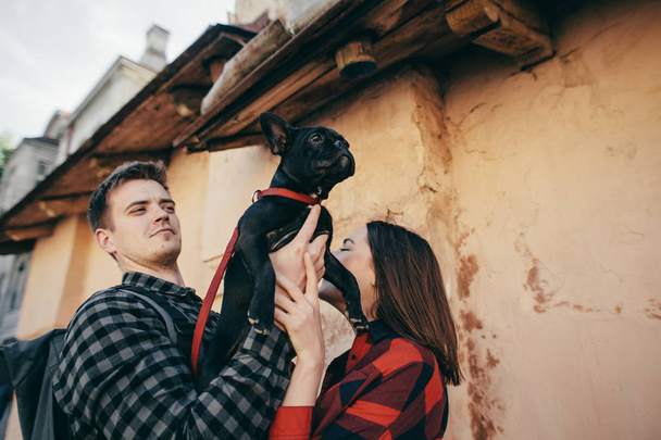 Loving couple with pet french bulldog - Фото, изображение