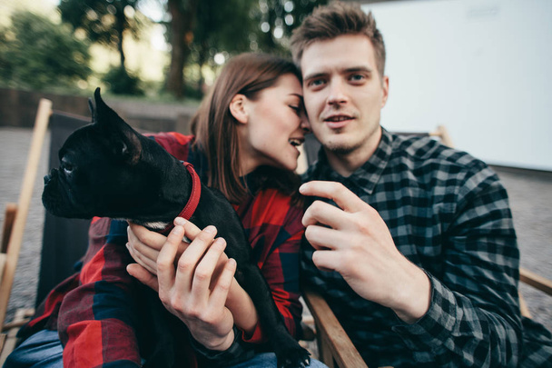 glückliches Hipster-Paar mit Bulldog, Sommerurlaub. stilvolle Familie mit lustiger Hunderuhe, netten Momenten - Foto, Bild