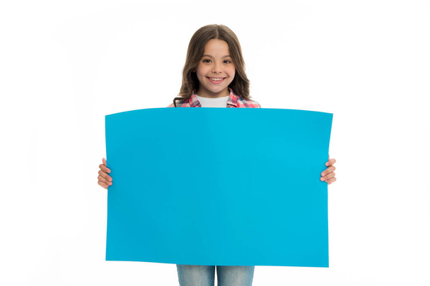 Children market advertisement. Girl kid holds blue blank surface copy space. Advertisement concept. Child cute girl looking happy while carries blue paper. Kid cheerful face sincere recommendation - Foto, Imagen