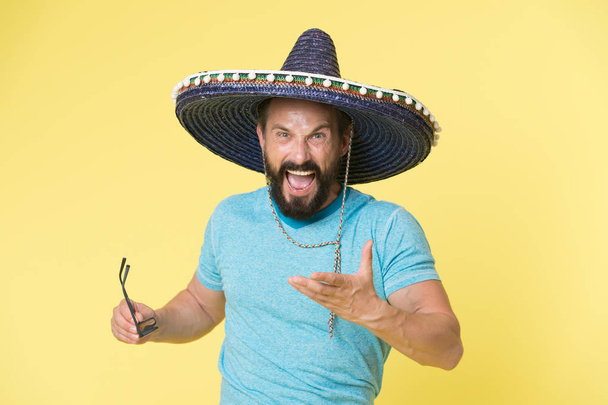 Hot tempered people. Man shouting face in sombrero hat yellow background. Guy with beard looks annoyed or angry in sombrero. Traditional rules of behaviour and manners. Man annoyed behaviour shout - Fotó, kép