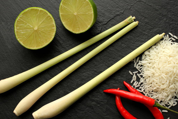 Жасминовый рис, красный перец чили, лаймы и лимонная трава на доске, вид сверху, пространство для копирования
 - Фото, изображение