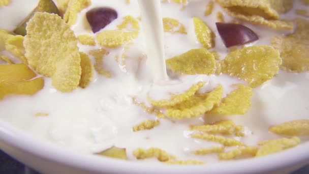 Movimiento lento en copos de maíz vierta la leche de cerca
 - Imágenes, Vídeo